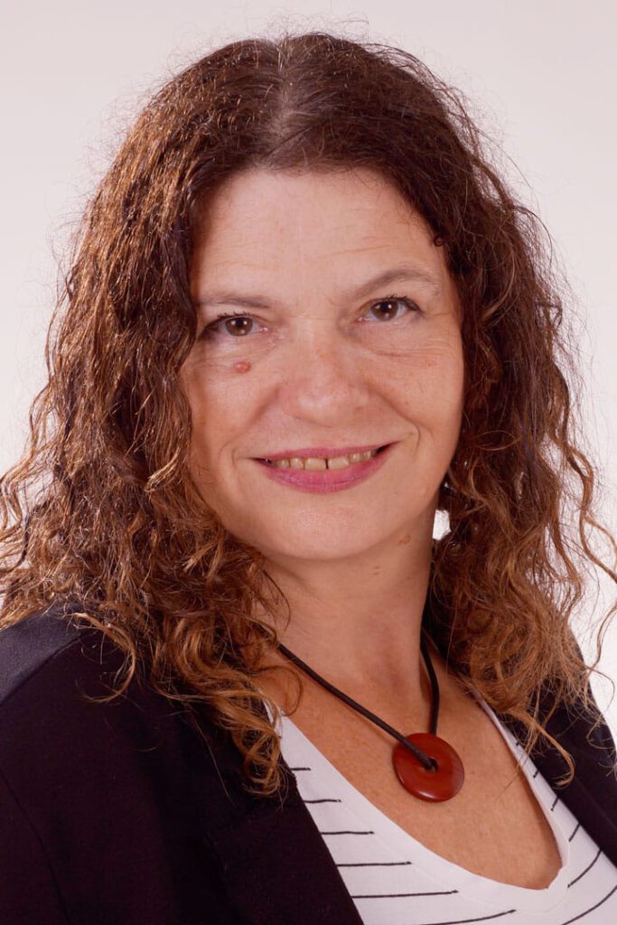Barbara Behrens ist eine erfahrene Frau mit braunem welligen Haar. Sie lächelt freundlich.